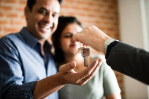 Happy couple receiving keys to their new home