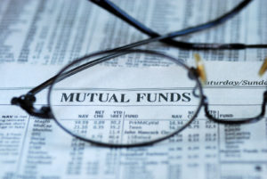 Eye glasses focusing on the Mutual Funds section in the newspaper